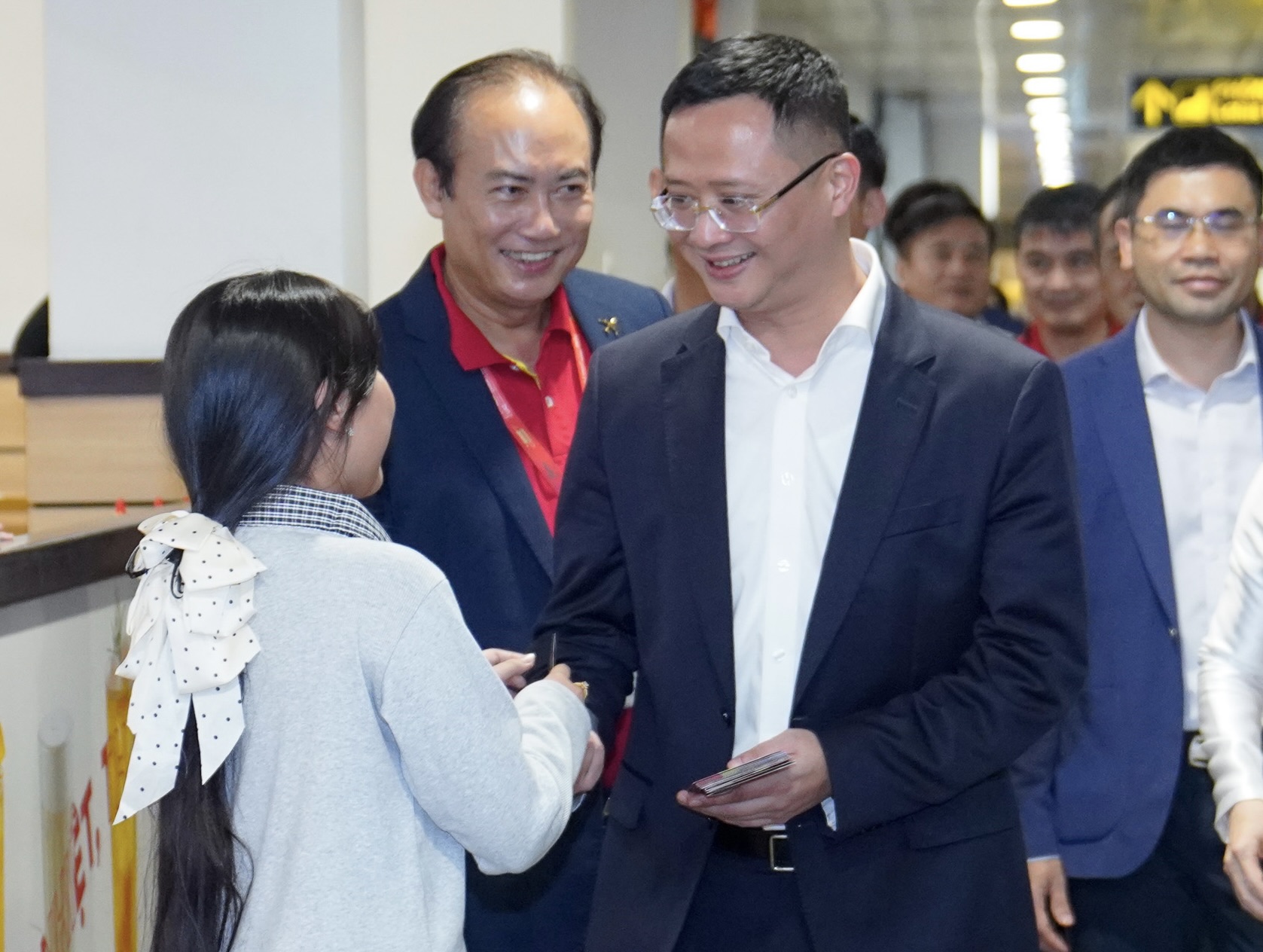 A group of people standing in a roomDescription automatically generated