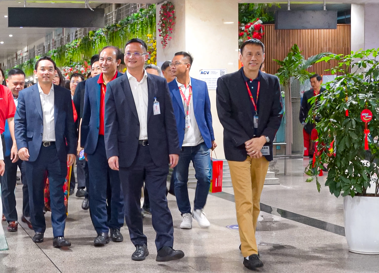 A group of people walking in a buildingDescription automatically generated